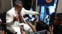 Kuasa hukum tersangka kasus dugaan korupsi eks Jampidsus Febrie Adriansyah, Hotman Paris Hutapea (tengah) menyampaikan keterangan kepada wartawan tengah duduk di kursi roda, Kamis (23/7/2026).
