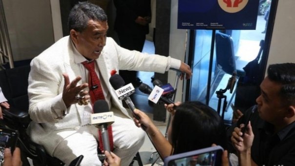 Kuasa hukum tersangka kasus dugaan korupsi eks Jampidsus Febrie Adriansyah, Hotman Paris Hutapea (tengah) menyampaikan keterangan kepada wartawan tengah duduk di kursi roda, Kamis (23/7/2026).